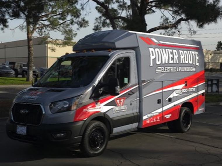 A Power Route Electric and Plumbing service van parked on a residential street.