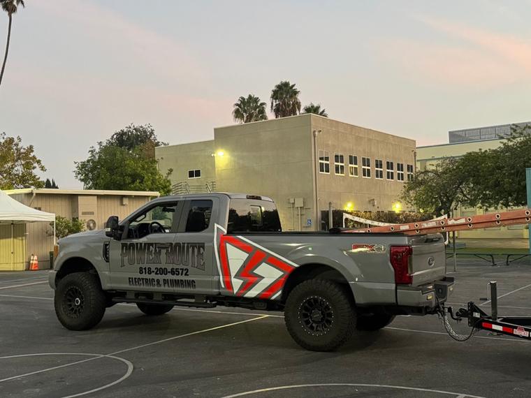 A Power Route service truck with a trailer at a commercial job site.